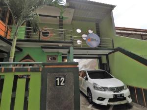 a white car parked in front of a building at Dhika Adventure in Probolinggo