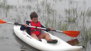 a young boy sitting in a kayak in the water at BeachLiving Cortegaça in Cortegaça
