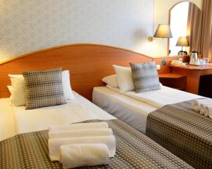 Postel nebo postele na pokoji v ubytování Hotel Orion Várkert