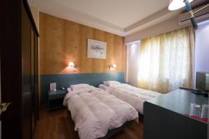 A bed or beds in a room at Minoa Athens Hotel