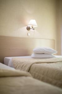 a hotel room with two beds and a lamp at Minoa Athens Hotel in Athens