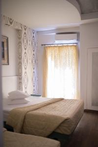 A bed or beds in a room at Minoa Athens Hotel