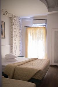 a bedroom with a bed and a window at Minoa Athens Hotel in Athens