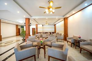 une salle d'attente avec des chaises, des tables et un ventilateur de plafond dans l'établissement Premier Vang Vieng Hotel, à Vang Vieng