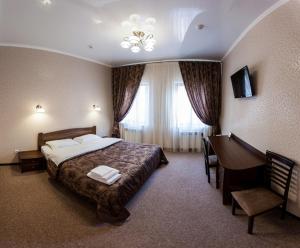 a hotel room with a bed and a desk at Отель "София" in Vinnytsya