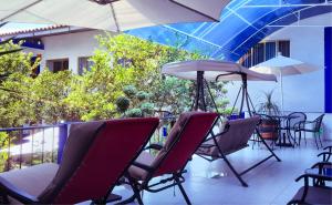 een groep stoelen en parasols op een balkon bij Hostal Plaza Central in Tetela de Ocampo