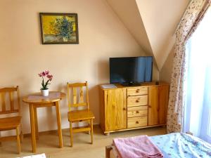 a bedroom with a tv on a wooden dresser with a table and chairs at U Schabińskiej Chyrowianka Gościniec in Dukla