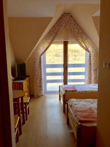 a bedroom with two beds and a large window at U Schabińskiej Chyrowianka Gościniec in Dukla