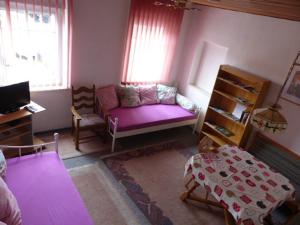 sala de estar con sofá púrpura y mesa en Ferienwohnung Baierl en Nördlingen