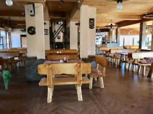 a restaurant with wooden tables and chairs in a room at U Schabińskiej Chyrowianka Gościniec in Dukla