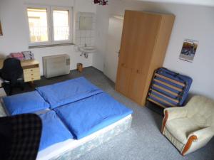 1 dormitorio con cama con sábanas azules y silla en Ferienwohnung Baierl en Nördlingen