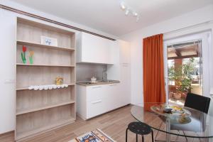 Apartments Cocaletto في روفينج: مطبخ وغرفة طعام مع طاولة زجاجية
