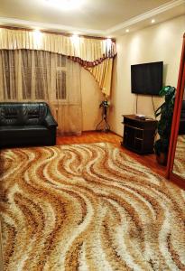 a large rug in a living room with a couch at Tiraspol Apartments in Tiraspol