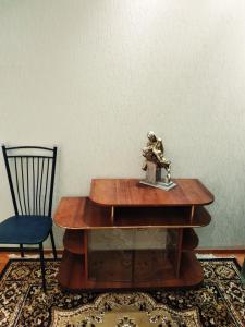 einen Tisch mit einer Statue darüber neben einem Stuhl in der Unterkunft Tiraspol Apartments in Tiraspol
