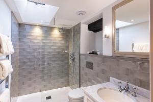 a bathroom with a sink and a toilet and a mirror at The Castle Inn in Castle Combe
