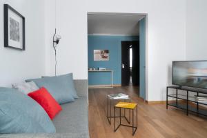 ein Wohnzimmer mit einem Sofa und einem TV in der Unterkunft Brera Apartments Alla Scala in Mailand