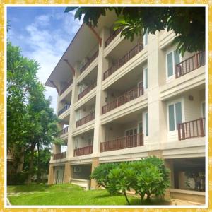 een groot gebouw met balkons en bomen ervoor bij ห้องชุด 2 ห้องนอน ริมหาด ณ บ้านทะเลสำราญ ชะอำ in Ban Khlong Khot