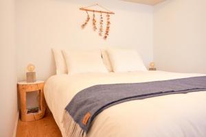 1 dormitorio con 1 cama con sábanas blancas y suelo de madera en UNIK Porto Apartment en Oporto
