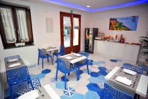 a restaurant with blue chairs and tables in a room at Costa Blu in Agerola