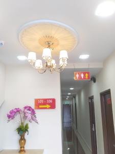 a chandelier in a hallway with a vase of flowers at Hotel Victory Inn KLIA and KLIA 2 in Sepang