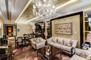 Narcissus Riyadh Hotel & Spa في الرياض: غرفة معيشة مع أريكة وثريا