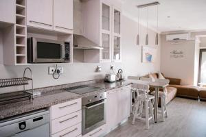 a kitchen with white cabinets and a counter top at 61 Cabanas in Durban