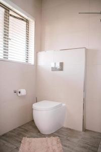 ダーバンにある61 Cabanasのトイレと窓のある白いバスルーム +9枚の写真