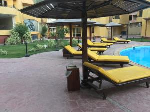 a group of yellow lounge chairs next to a pool at Pool View Apartment At British Resort Unit 221 in Hurghada