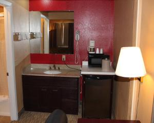 cocina con fregadero y pared roja en Valustay Inn Shakopee, en Shakopee