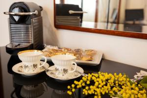 uma mesa com duas chávenas de chá e um prato de comida em Room Cavour, nearby Cinqueterre em La Spezia