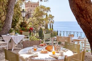 a restaurant with tables and chairs with a view of the ocean at Hotel Punta Est in Finale Ligure