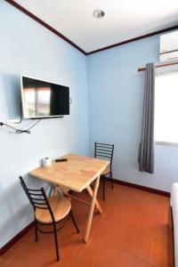 a dining room with a wooden table and chairs at amenity@22 in Bangkok