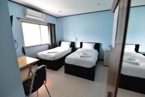 a small room with two beds and a desk at amenity@22 in Bangkok