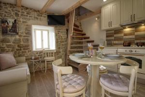 eine Küche und ein Wohnzimmer mit einem Tisch und Stühlen in der Unterkunft ADORA in Motovun