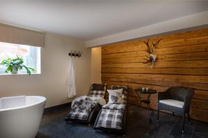 ein Badezimmer mit 2 Stühlen und einer Badewanne in der Unterkunft Chalet Jagdhof in St. Johann im Pongau