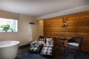 a bathroom with two chairs and a bath tub at Chalet Jagdhof in Sankt Johann im Pongau