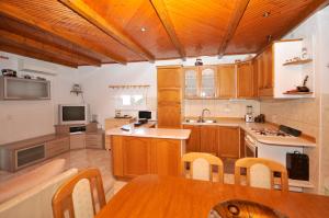 a kitchen with wooden cabinets and a wooden table at Apartman Elena in Trogir