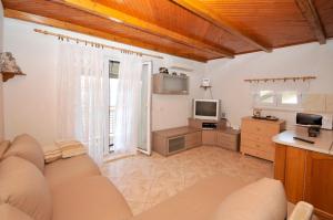 salon z kanapą i telewizorem w obiekcie Apartman Elena w Trogirze