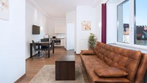 a living room with a brown couch and a table at Aparthotel - Stadtvilla Premium in Schweinfurt