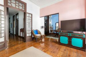a living room with a television and a table at Charming Guest House in a 19th Century Building in Lisbon