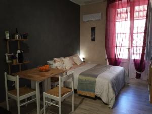 um quarto com uma cama e uma mesa com cadeiras em Chafbius Downtown em Cagliari