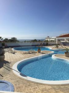 a swimming pool in a resort with the ocean in the background at Tenerife Luxury Apartment Costa Adeje in Adeje