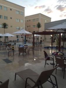 un patio extérieur avec tables, chaises et parasols dans l'établissement Encontro das Águas Thermas Resort, à Caldas Novas