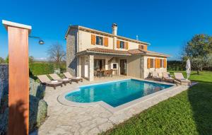 a villa with a swimming pool in front of a house at Villas Adagio in Rojnići