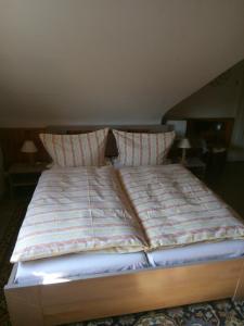 Bett mit gestreifter Bettdecke und 2 Kissen in der Unterkunft apartricanova in Prag