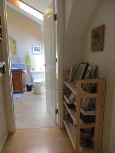 a bathroom with a toilet and a book shelf at Tea Cozy Bed & Breakfast in Qualicum Beach