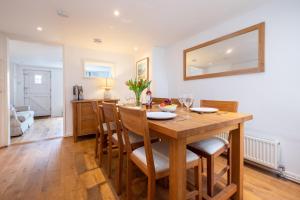 una cucina e una sala da pranzo con tavolo e sedie in legno di Puddleduck Cottage ad Aldeburgh