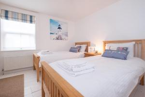 ein Schlafzimmer mit zwei Betten und einem Fenster in der Unterkunft Puddleduck Cottage in Aldeburgh