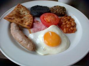 ein Frühstücksteller mit Eiern, Würstchen, Bohnen und Toast in der Unterkunft Creebridge House Hotel in Newton Stewart