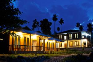 a house lit up at night with lights at Cakalang Resort in Bunaken